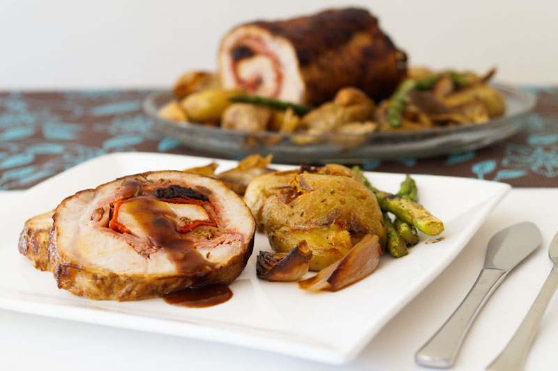 Lomo de cerdo relleno al horno con patatas, cebollitas, setas y esparragos